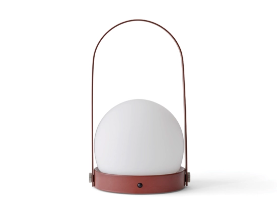 Front view of a burned red Carrie Table Lamp with a white globe shade and tall curved carry handle