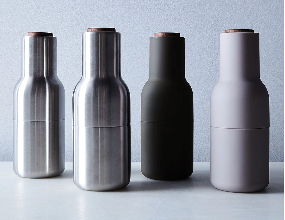 Four Audo Bottle Grinders in brushed silver, dark green and grey, all with brown wooden lids